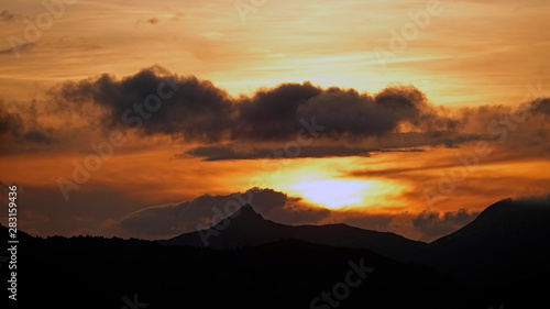 beautiful sunset in the mountains with orange sky and view to the alps