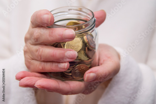 woman hands with glass jar and coins  saving concept