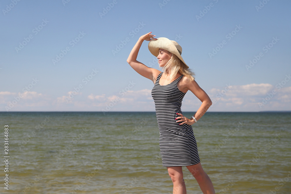 Naklejka premium young girl in a dress and a summer hat