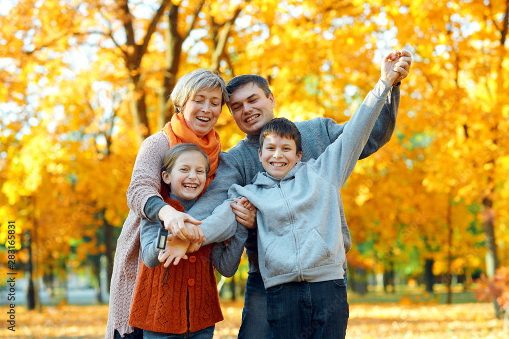 Happy family posing, playing and having fun in autumn city park. Children and parents together having a nice day. Bright sunlight and yellow leaves on trees, fall season. Happy family posing, playing and having fun in autumn city park. Children and parents together having a nice day. Bright sunlight and yellow leaves on trees, fall season.