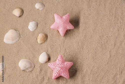  Dream of a combination of white seashells and decorative colored stars on a sandy beach background