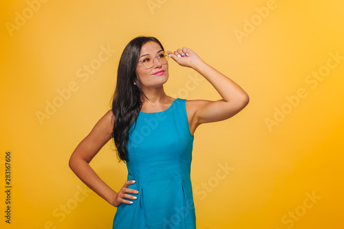 Girl on a yellow background touching glasses