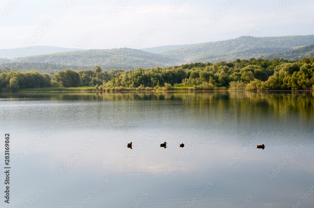 beautiful summer lake against the background of high mountains and blue sky