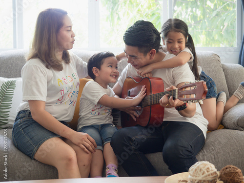 Father playing guitar for family