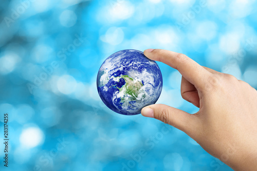 Hand Holding Earth On Blue Bokeh Background, Save The World Concept,Elements of this image furnished by NASA