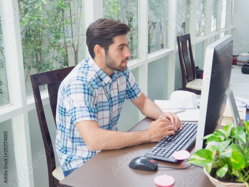 young man working at home ,businessman works on his computer to get all his business