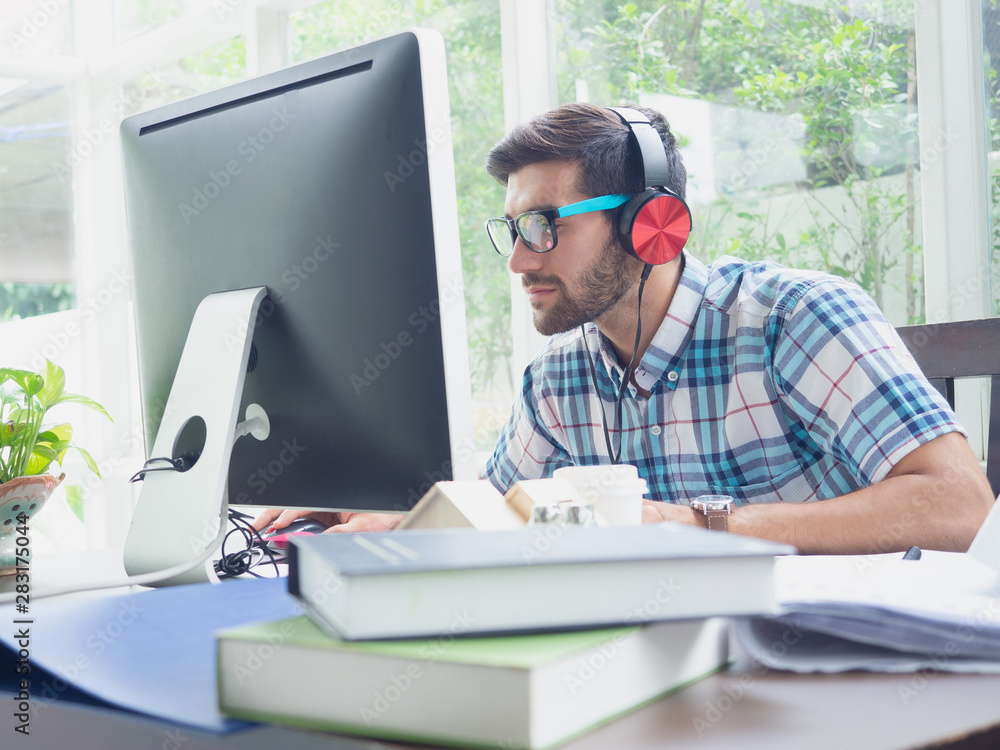 young man relax at home with earphone ,businessman works on his computer to get all his business young man relax at home with earphone ,businessman works on his computer to get all his business