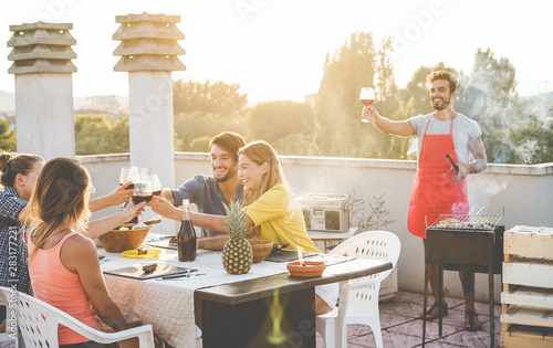 Sticker Young friends having barbecue party at sunset on roof top terrace - Happy people
