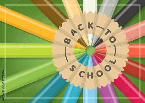 Back to school concept with realistic multicolor wooden color pencils in circular alignment on green background from close up top view