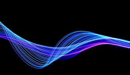 Long exposure, light painting photography.  Vibrant streaks of neon blue and pink color against a black background.