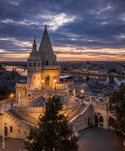 Budapest, Hungary - The main tower of the famous Fisherman's Bastion (Halaszbastya) from above with Parliament building and River Danube at background at sunset,sunrise,blue hour, night