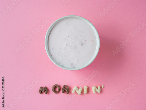 cereal breakfast bowl with yogurt and cherry on pink background top view