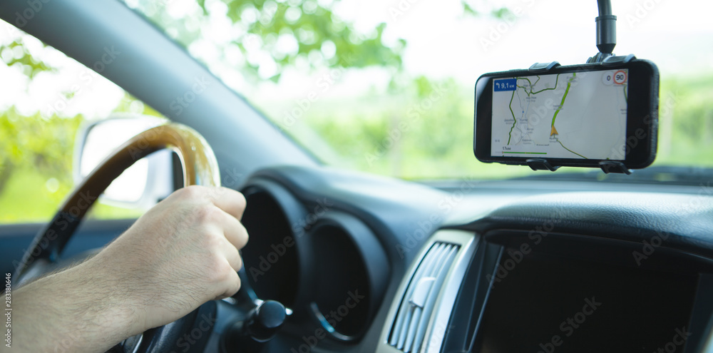 The driver uses a mobile smartphone with a GPS map navigation application.