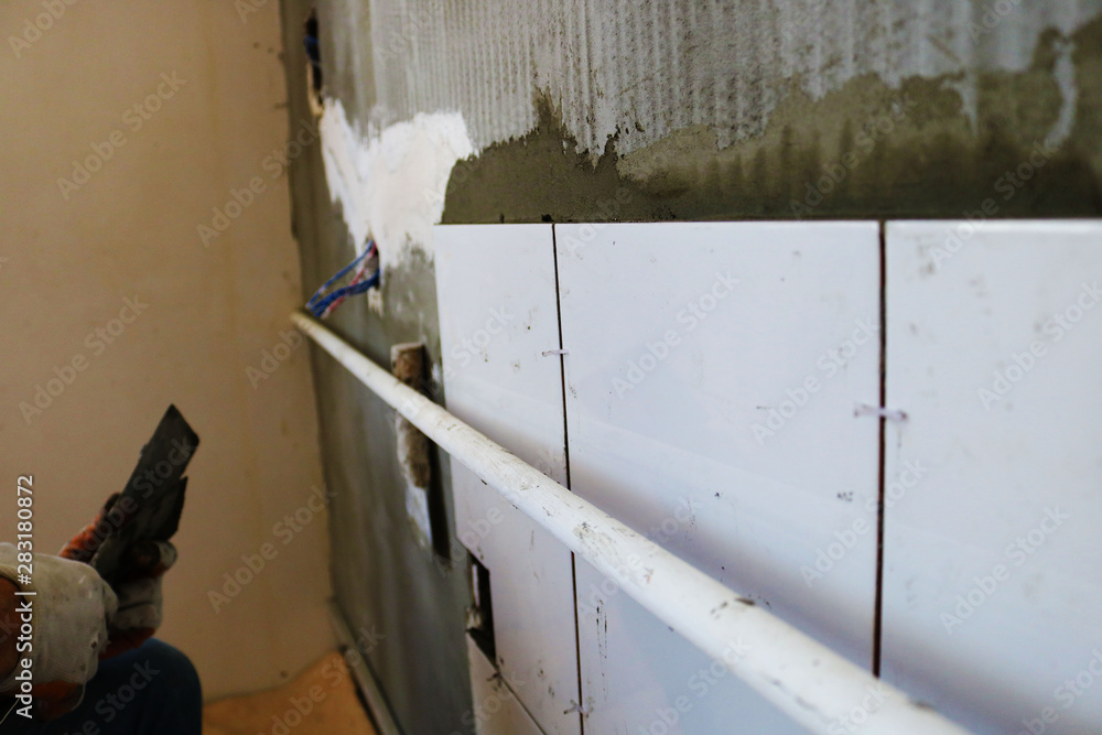 Repair concept. Ceramic tiles. The master lays ceramic tiles on the wall Repair concept. Ceramic tiles. The master lays ceramic tiles on the wall