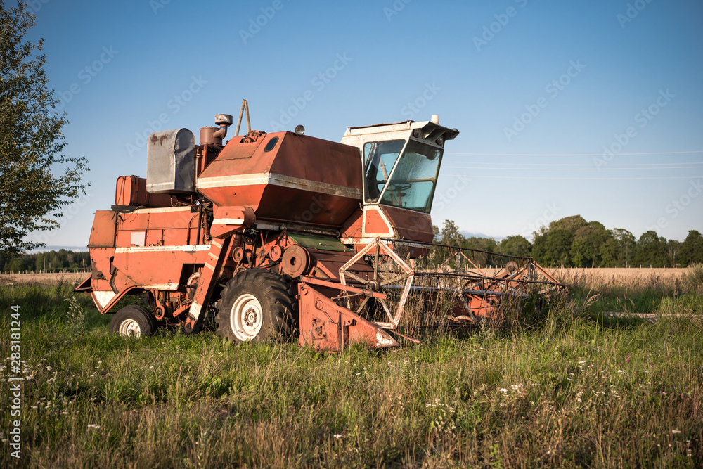 Fototapeta premium Old grain harvester in the field