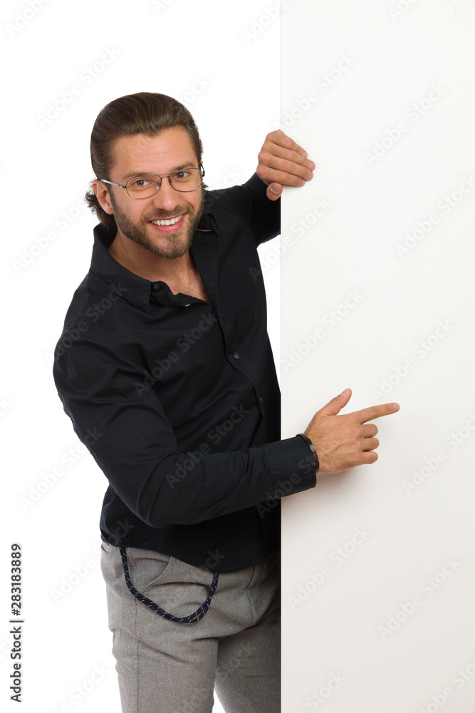 Smiling Man In Black Shirt And Eyeglasses Is Standing Next To Big Banner And Pointing Smiling Man In Black Shirt And Eyeglasses Is Standing Next To Big Banner And Pointing