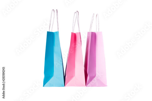 Three paper pink, purple,blue shopping bags isolated. Top view.