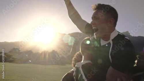 Excited rugby players celebrating win at the field. Rugby team enjoying after the victory.