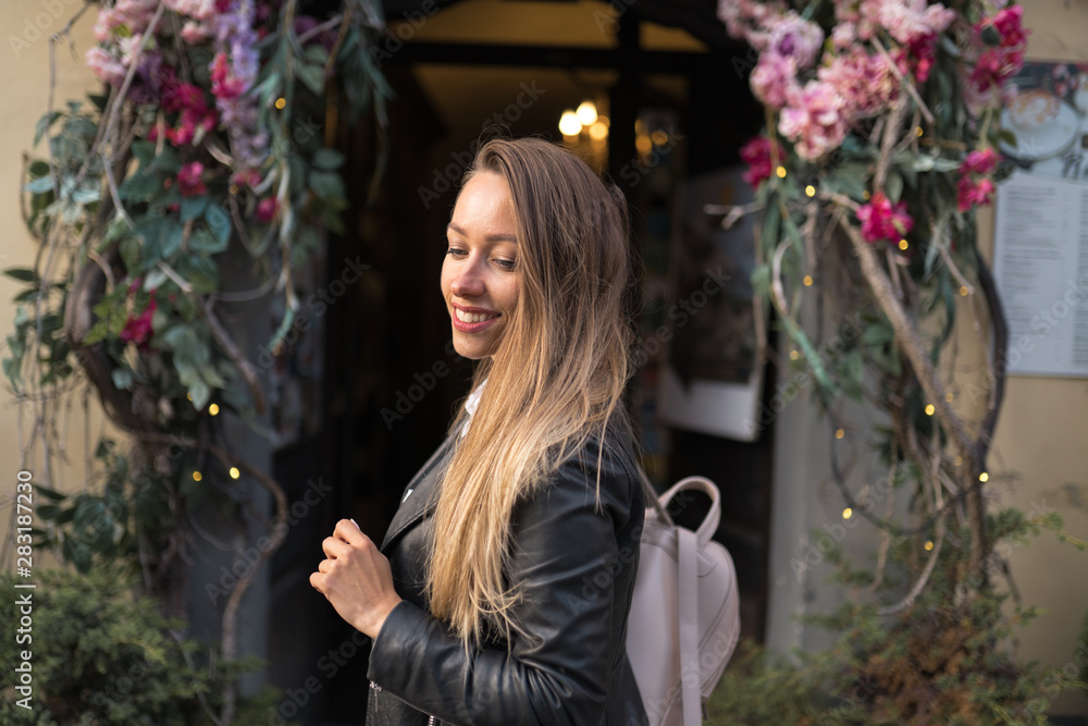 Happy woman portrait sexy moving on the flower arch background in beautiful Riga old town Happy woman portrait sexy moving on the flower arch background in beautiful Riga old town