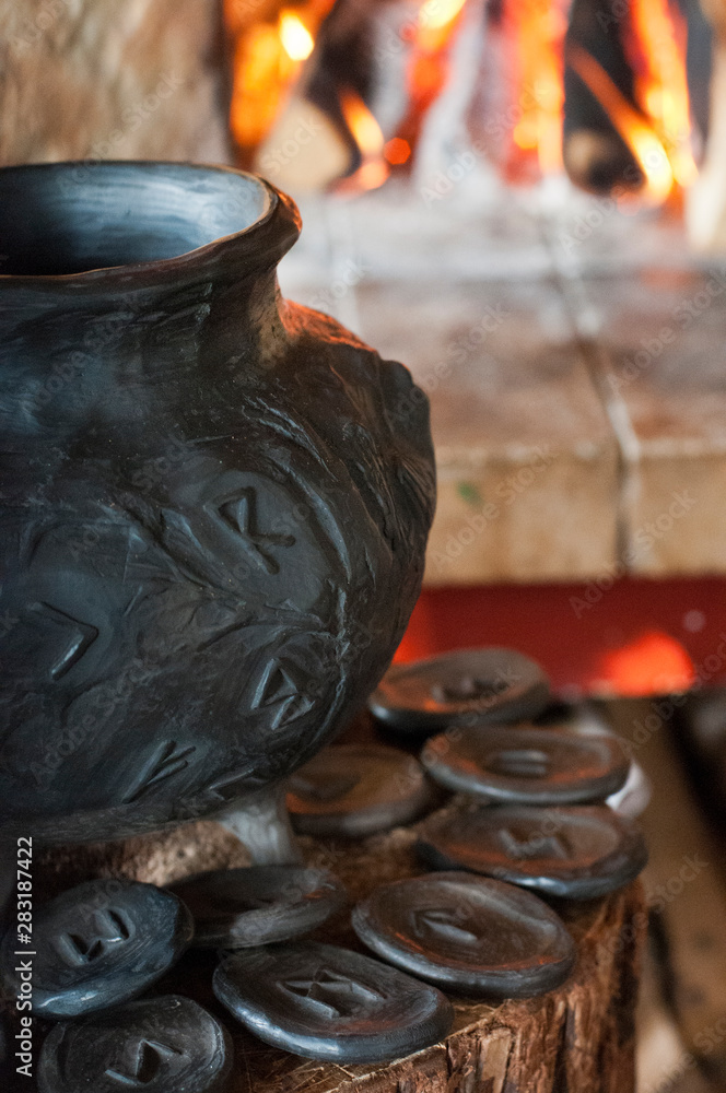 Runic pot on a wooden log with smoke Runic pot on a wooden log with smoke
