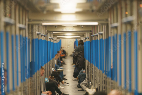Passengers in the subway. Photo of a subway car. Young people look at smartphones. Modern high tech culture.