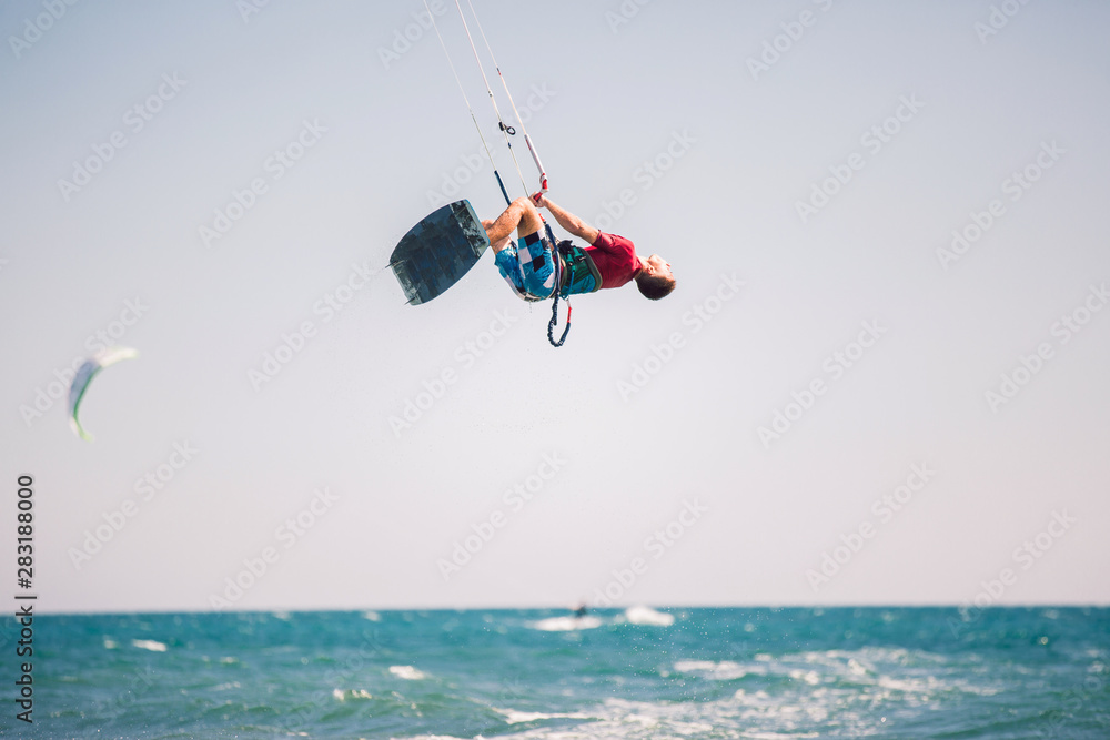Professional kiter makes the difficult trick on a beautiful background. Kitesurfing Kiteboarding action photos man among waves quickly goes Professional kiter makes the difficult trick on a beautiful background. Kitesurfing Kiteboarding action photos man among waves quickly goes