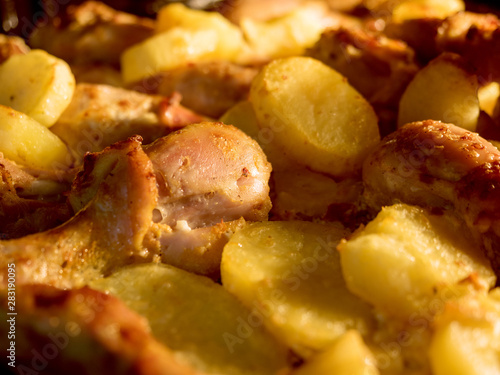 Appetizing chicken with baked potatoes in oven