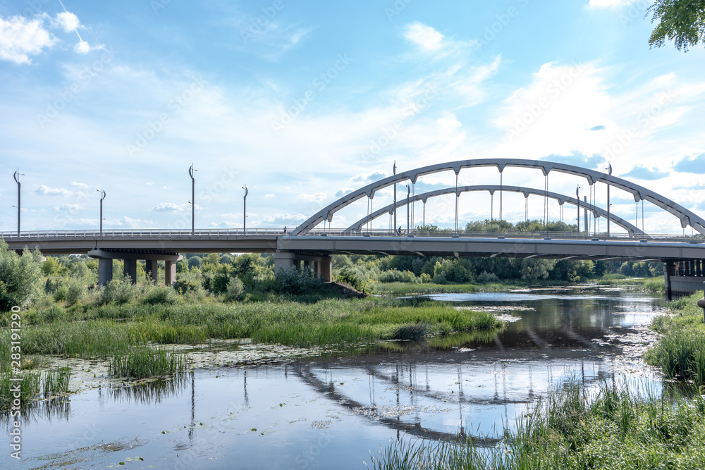 Big steel bridge over the river in Brest, Belarus, on the summer day. Architecture and nature in one picturesque lanscape Big steel bridge over the river in Brest, Belarus, on the summer day. Architecture and nature in one picturesque lanscape