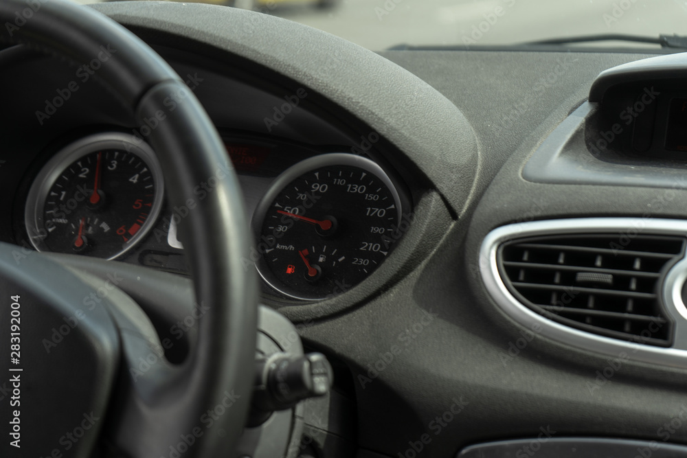 Car on the road. Black car interior. Dashboard, steering wheel, speedometer. Speed ​​Compliance