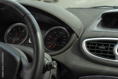 Car on the road. Black car interior. Dashboard, steering wheel, speedometer. Speed ​​Compliance © MoonfliesPhoto