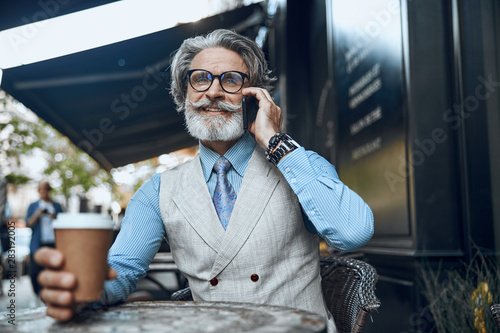 Mirthful man with coffee talking on the phone stock photo © Yakobchuk Olena