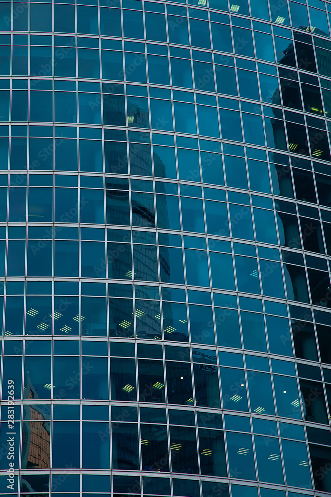 part of the facade of a glass skyscraper. The city's modern architectural background