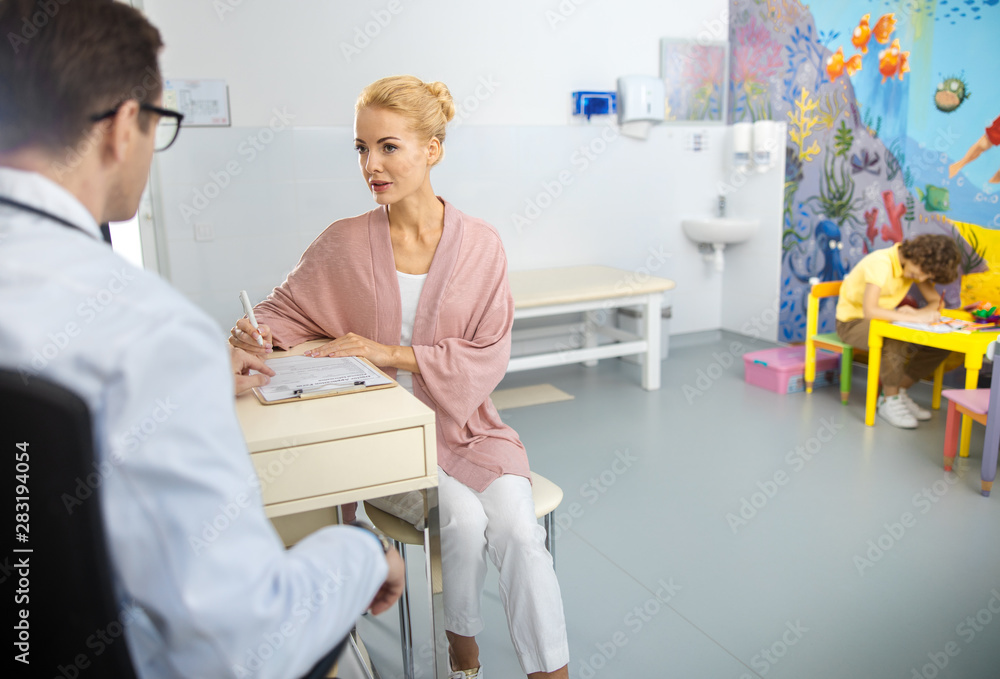 Obraz premium Woman visiting physician with son stock photo