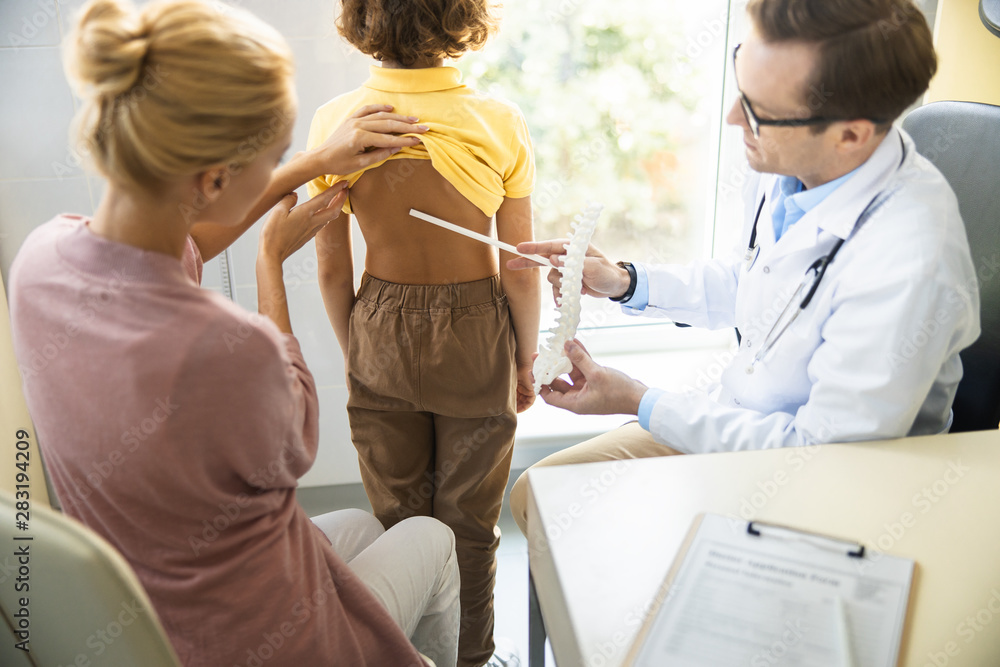 Physician checking boy back problems stock photo Physician checking boy back problems stock photo