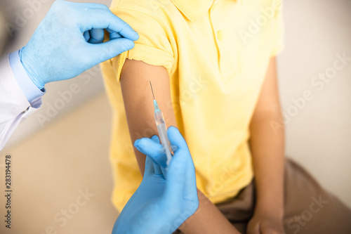Child getting injection by practitioner stock photo