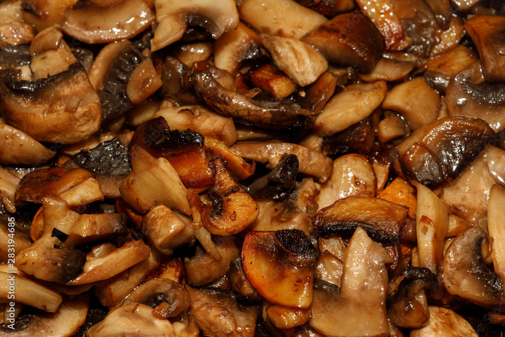 Fried champignon mushrooms in a pan closeup background texture Fried champignon mushrooms in a pan closeup background texture