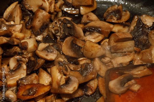 Fototapeta Naklejka Na Ścianę i Meble -  Fried champignon mushrooms in a pan closeup background texture