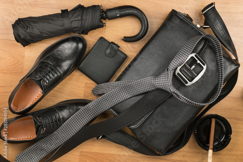 Beautiful black classic men's accessories, leather briefcase, belt, tie and shoes.
