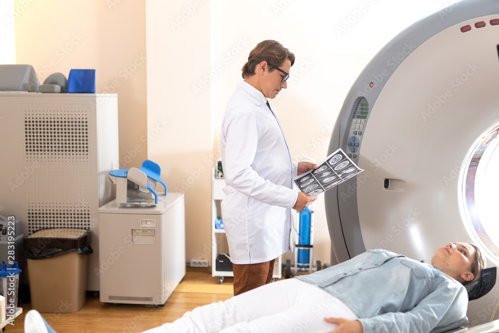 Doctor examining brain CT scan of young woman Doctor examining brain CT scan of young woman