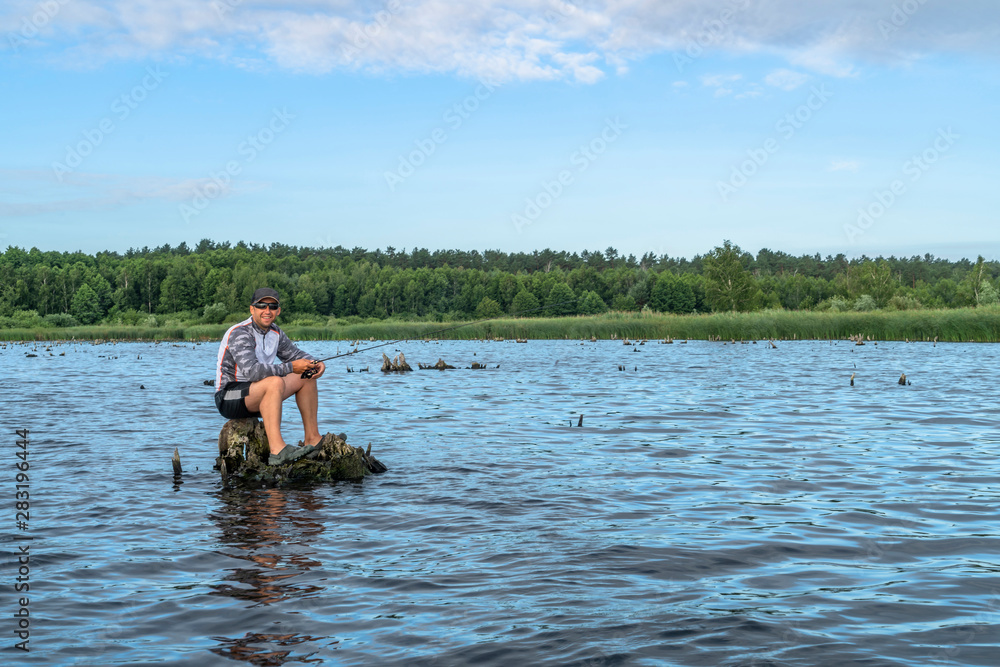 Fishing. Fisherman in action, lonely man catch fish by spinning rod