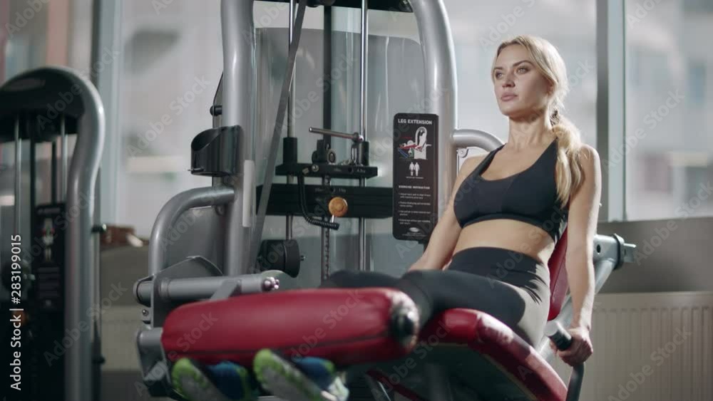 Sport woman making leg exercise on fitness machine in fitness gym. Sport woman making leg exercise on fitness machine in fitness gym.