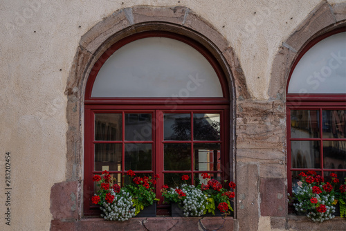 Red window in Colmar, France. Beautiful red flowers at the windows.