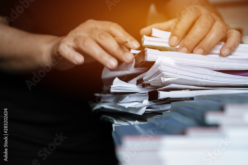 Quadro em tela Business documents paperwork overwork concept : Employee people hands working in stacks paper files for searching and checking unfinished document report on folders print at busy work desk office