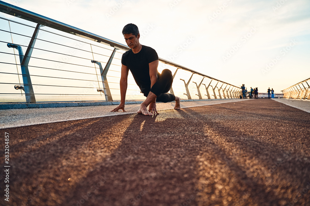 Young man doing exercise early in the morning on a pathway