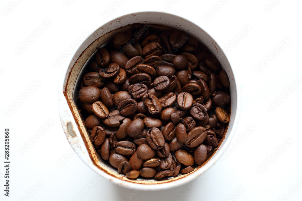 Freshly roasted fresh aromatic coffee beans in a coffee grinder on a white background, ground coffee, making coffee Freshly roasted fresh aromatic coffee beans in a coffee grinder on a white background, ground coffee, making coffee