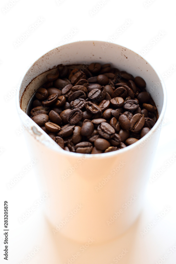 Freshly roasted fresh aromatic coffee beans in a coffee grinder on a white background, ground coffee, making coffee Freshly roasted fresh aromatic coffee beans in a coffee grinder on a white background, ground coffee, making coffee