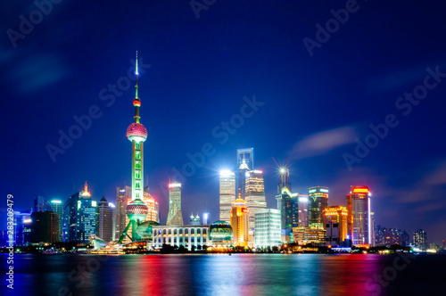 Shanghai. Night view of the financial district of the Pudong viewed from The Bund, with the light of buildings reflected on the Huangpu river