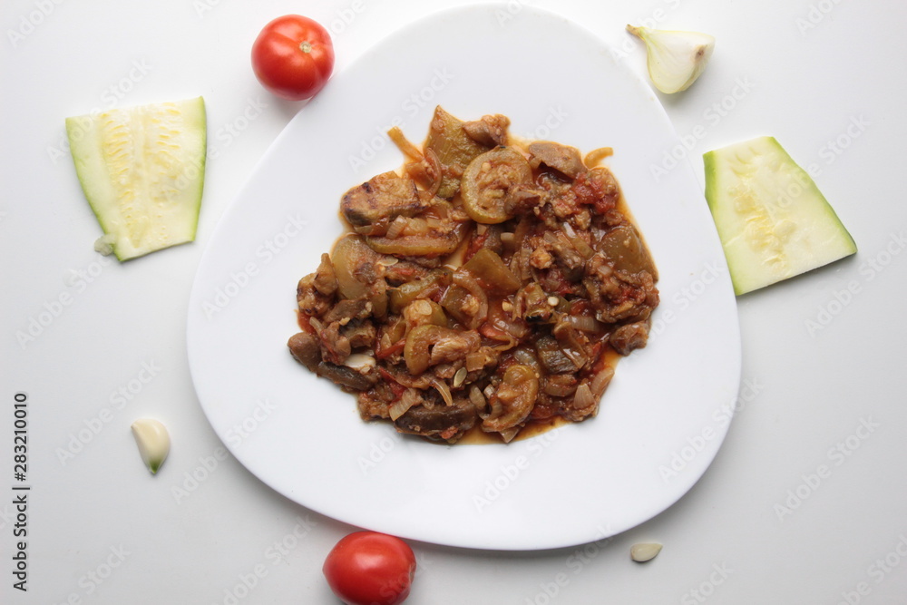 Vegetable stew on white plate with tomato, garlic, onion, squash Vegetable stew on white plate with tomato, garlic, onion, squash