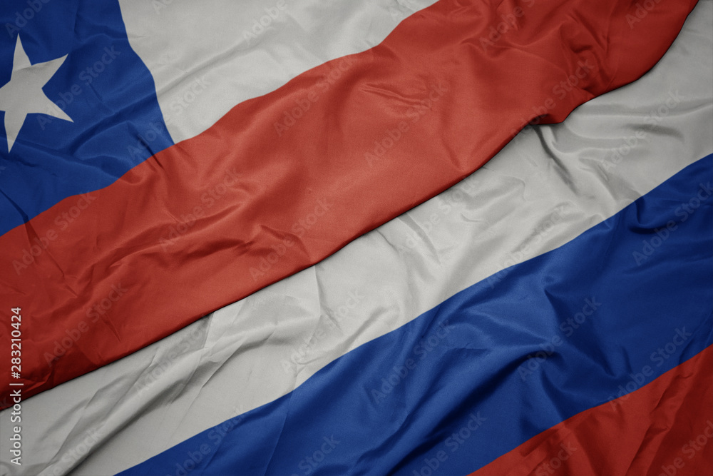 waving colorful flag of russia and national flag of chile. waving colorful flag of russia and national flag of chile.