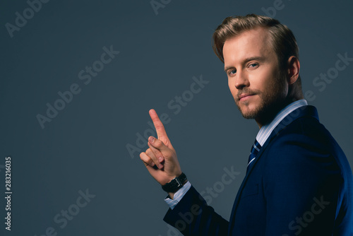 businessman hand point show one finger present invisible monitor screen isolate dark background